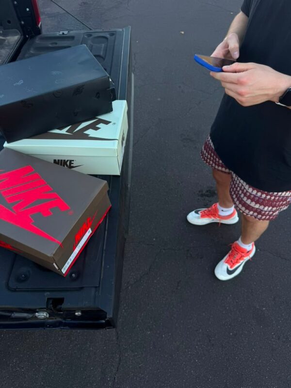 Customer receiving sneaker order by pickup truck tailgate